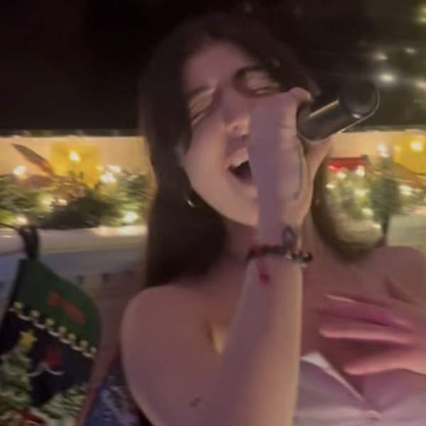 Nini singing, paw print stocking visible behind her