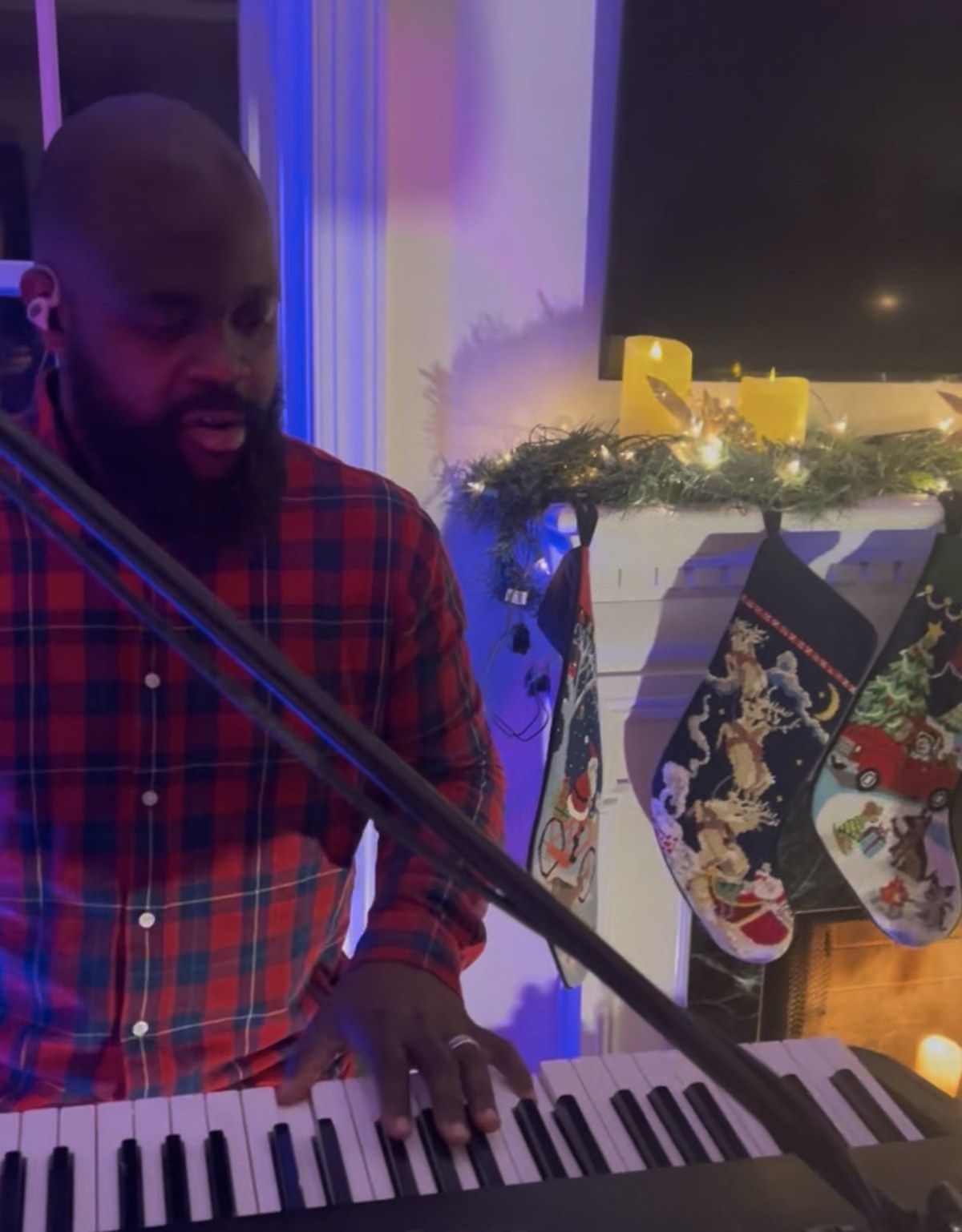 Singer performing next to the Christmas tree, stocking visible