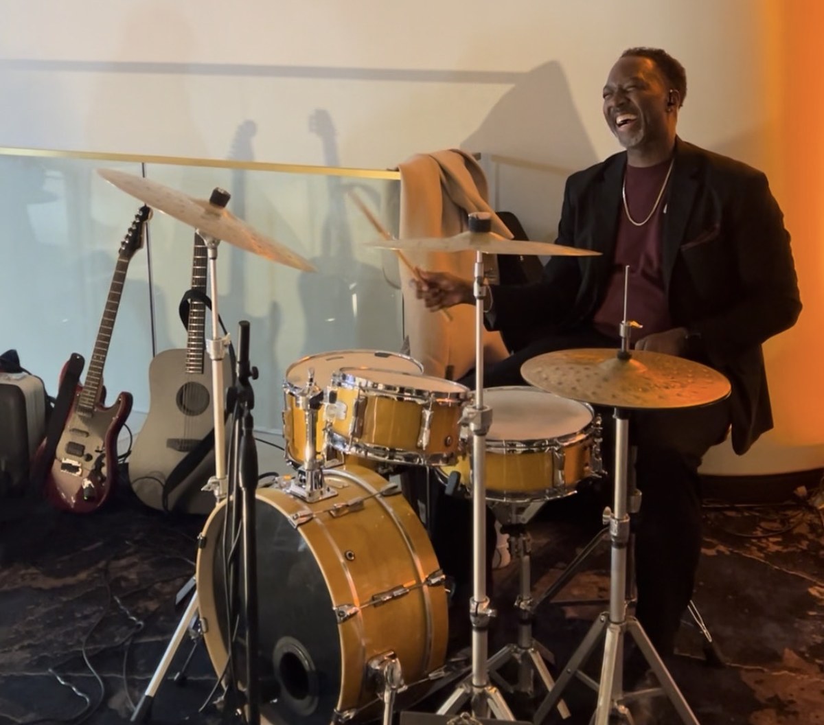 Drummer mid-set at the Heisman party, RequestWave QR code visible